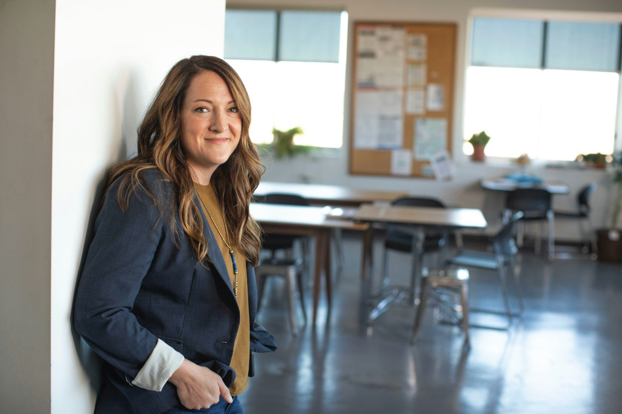 A smiling education professional standing in a classroom