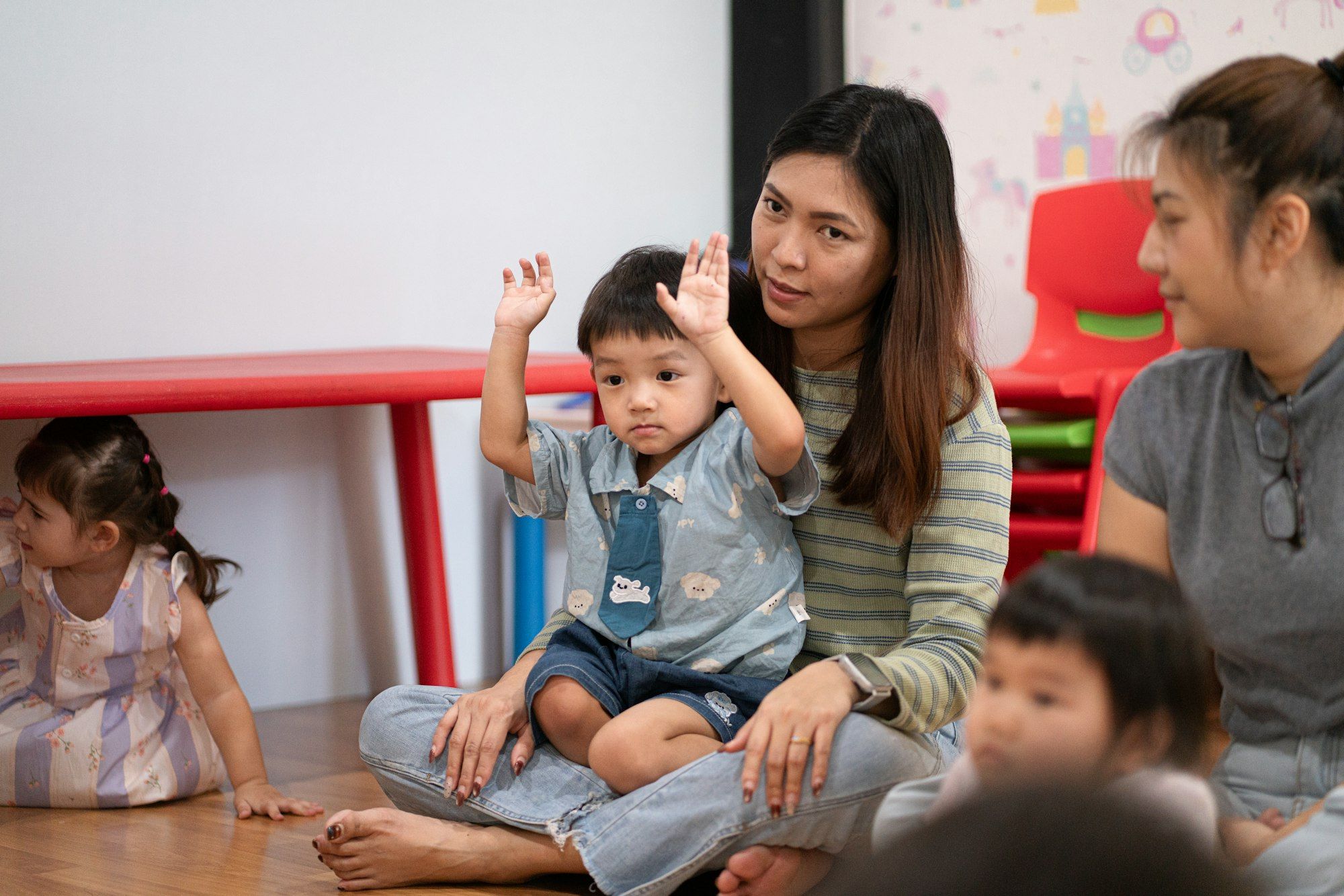 A teacher with young children in a bright early years classroom