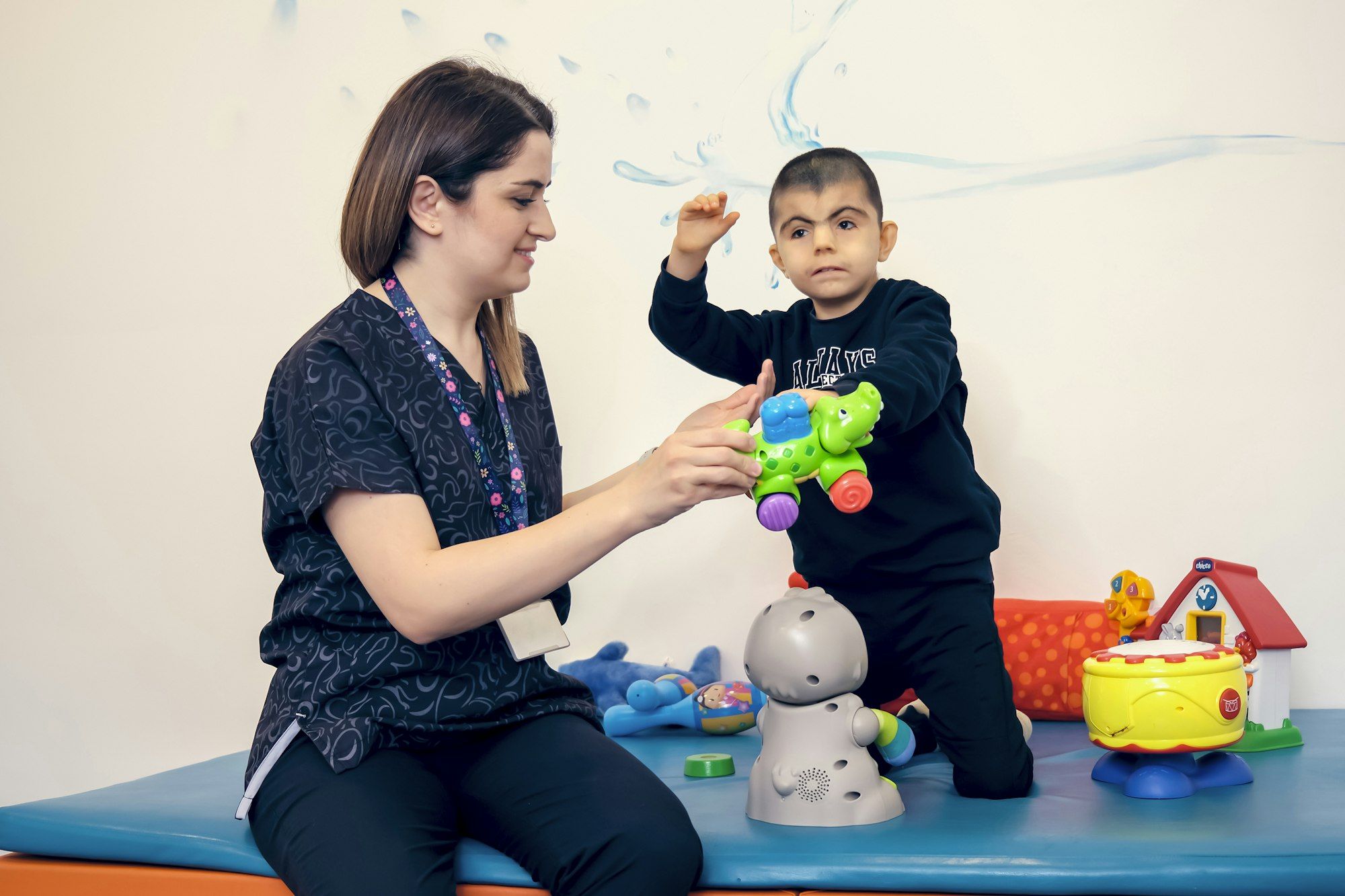 A specialist practitioner playing with a young child during a session